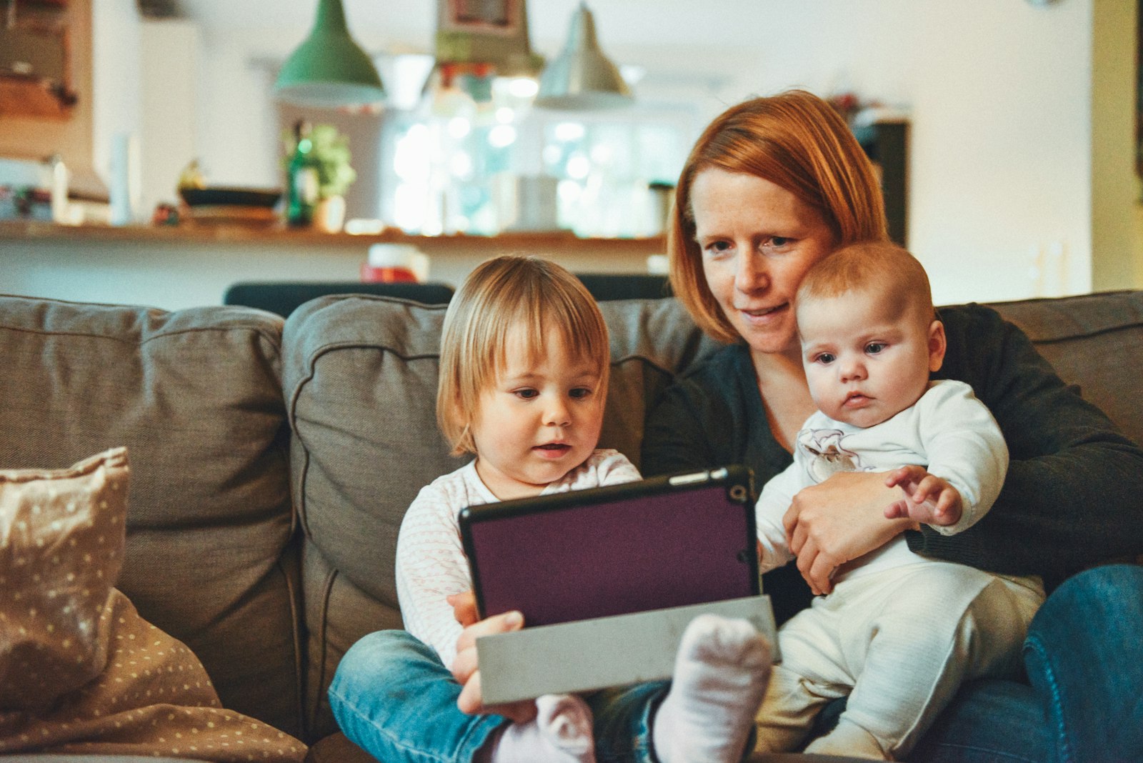 A mother and her children using a tablet at home